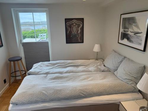 a large bed in a bedroom with a window at Fisketången Seaside Stay in Kungshamn