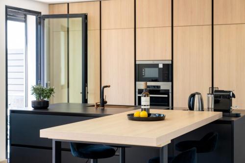 a kitchen with a table with a bowl of fruit on it at Villa Monégasque elegance & Exclusive seaside getaway in Sérignan