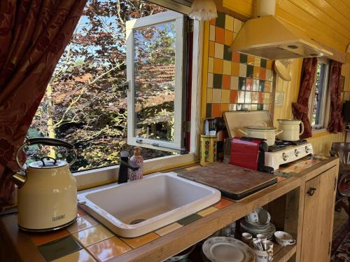 eine Küchentheke mit Spüle und Fenster in der Unterkunft B&B Maarle in Poppel