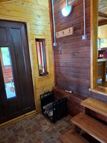 a room with a wooden wall and a wooden door at Cabana trenulețelor in Lunca Mare
