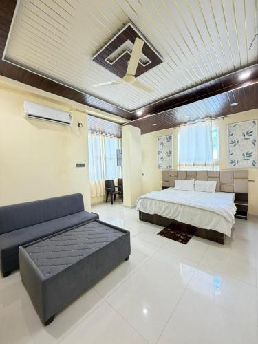 a large bedroom with a bed and a couch at Hotel Lotus Stay INN in Jabalpur