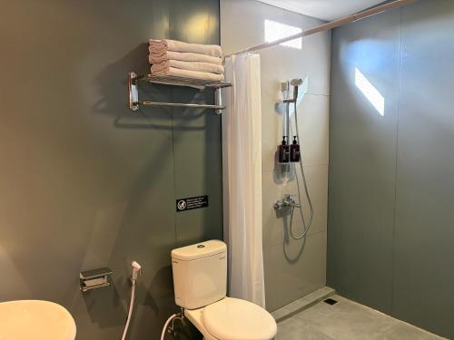 a bathroom with a toilet and a glass shower at Altha Stay Cokro in Ngabean