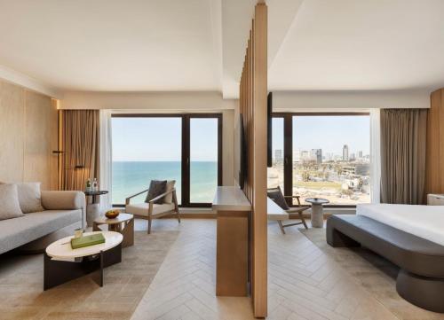 a hotel room with a bed and a living room at The Setai Tel Aviv, a Member of the leading hotels of the world in Tel Aviv