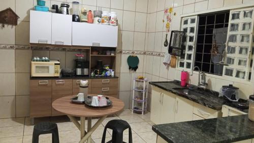 a kitchen with a wooden table and a small table at Quarto casal standart max in Ribeirão Preto