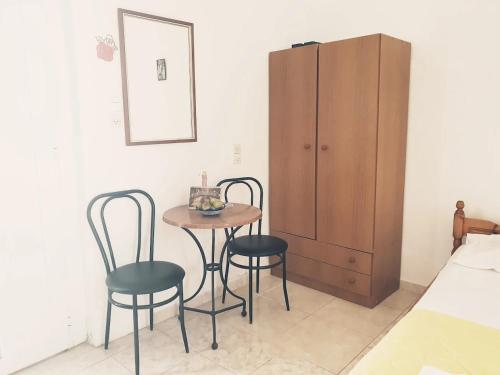 a bedroom with a table and two chairs and a cabinet at Studio Maria Lenta in Lentas