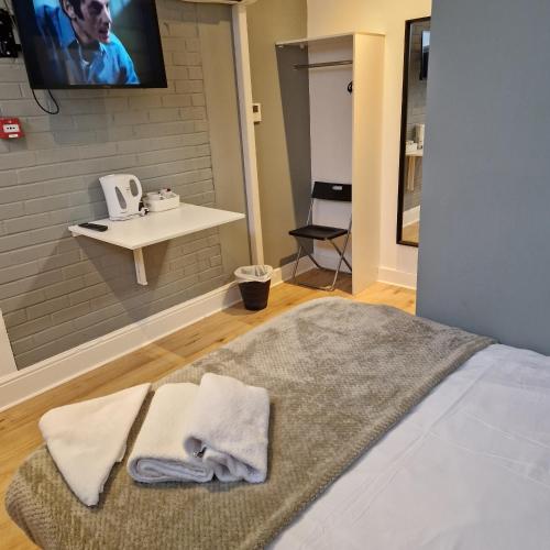 a bedroom with a bed with two towels on it at The Dorchester Hotel & serviced apartments FREE PARKING in Hull