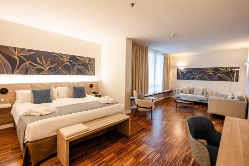 a bedroom with a large bed and a living room at Hotel Escuela Santa Cruz in Santa Cruz de Tenerife