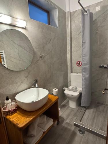 a bathroom with a sink and a mirror and a toilet at Charoula in Platanias