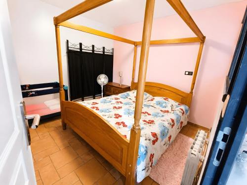 a bedroom with a wooden four poster bed at Gite 5 Pers proche Wimereux in Belle-et-Houllefort