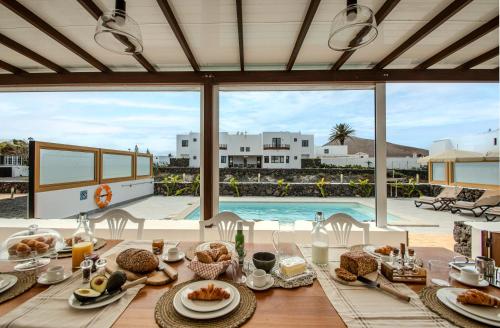 a table with food and a view of a pool at Villa Barrilla by Villalize in Tinajo