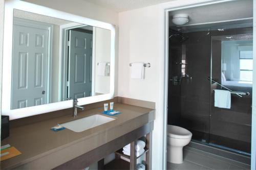 a bathroom with a sink and a mirror and a toilet at Hyatt House Dallas Uptown in Dallas