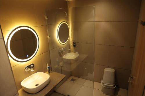 a bathroom with a sink and two mirrors at Sai Krishna Hill View Resort in Pawārkhera