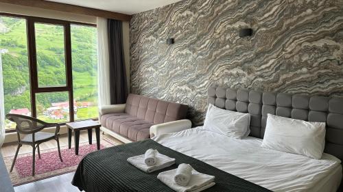 a bedroom with a king sized bed and a couch at Alya Teras Otel in Trabzon