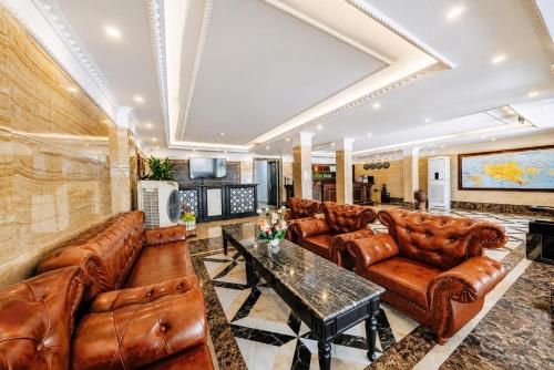 a living room with leather couches and a table at Cat Ba Violet Hotel and Apartment in Cat Ba