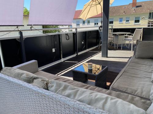 a patio with a couch and a table on a balcony at FeWo Wagner in Fuggerstraße in Dillingen an der Donau