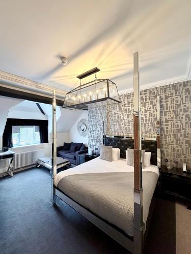 a bedroom with a large bed with a chandelier at The Mount Country Manor Hotel & Golf Wolverhampton in Wolverhampton