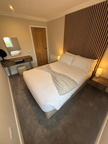 a bedroom with a large bed with white sheets and pillows at Raasay Apartment in Fort William