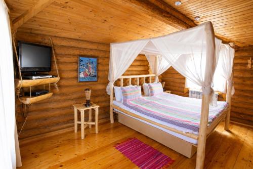 a bedroom with a bed in a log cabin at Nebesa Hotel EZ in Chimgan
