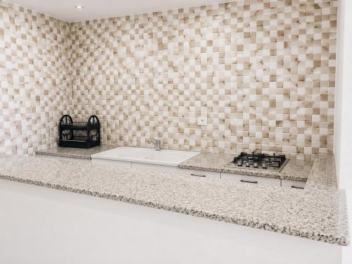 a kitchen counter with a sink and a stove at Casa del Mar Residences in Kelibia