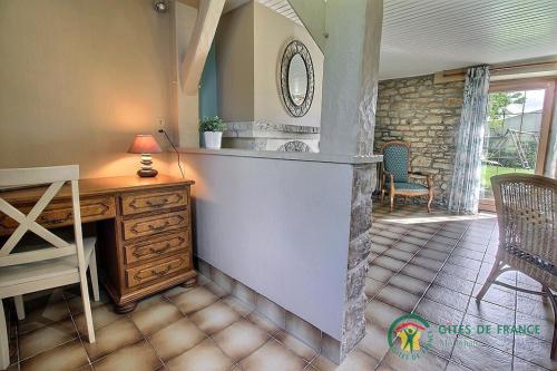 a home office with a desk and a table and chairs at 2 route de l'huître in Locoal-Mendon