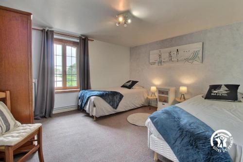 a bedroom with two beds and a window at 2 route de l'huître in Locoal-Mendon