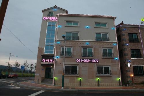 a large building with neon signs on the side of it at Boryeong Daecheon High Pension in Boryeong