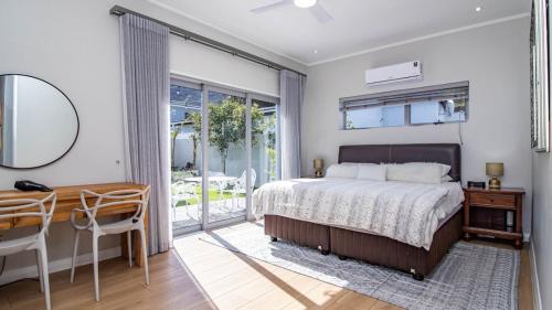 a bedroom with a bed and a table and a desk at Robin Retreat - Luxury 3 Bedroom Villa -Hermanus in Hermanus