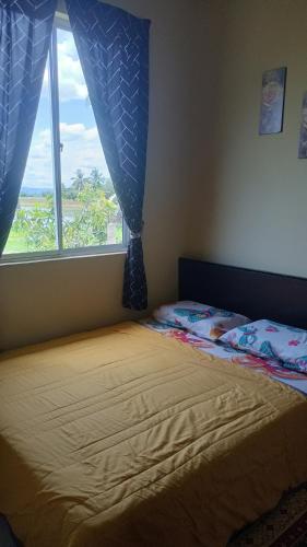 a bedroom with a bed with a large window at D'Shazly Homestay Village in Arau