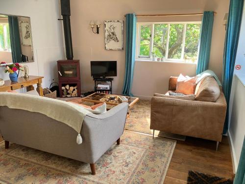 a living room with two couches and a tv at Simpers Drift, Great Glemham in Saxmundham