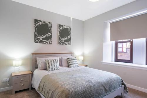 a white bedroom with a bed and a window at Almanythie Snug, Peterhead in Peterhead