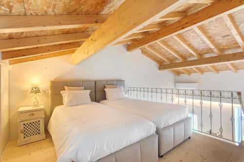 two beds in a bedroom with wooden ceilings at Vila Santa Luzia 2 in Fátima