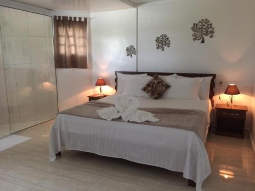 a bedroom with a large bed with two lamps and two tables at Hotel Pousada Recanto in Ilha Comprida