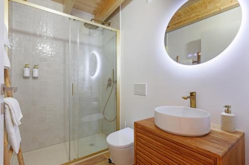 a bathroom with a sink and a shower with a mirror at Vila Santa Luzia 2 in Fátima
