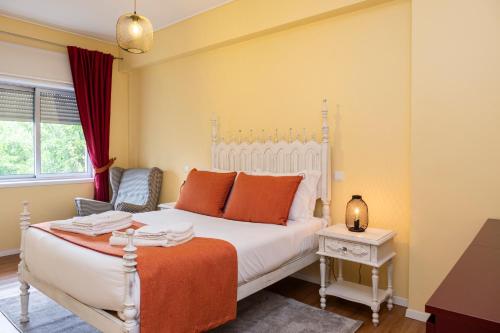 a bedroom with a white bed with orange pillows at RH Charming Apartment Liberdade I in Braga
