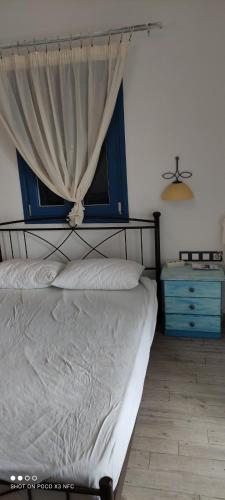 a bedroom with a bed with a window and a dresser at Cycladic residence, Saint George, Antiparos in Agios Georgios