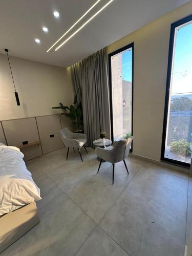 a bedroom with a bed and a table and chairs at TRIO Chalet 2 in Sowayma