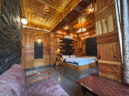 a room with a bed in a wooden cabin at The Rustic Jibhi - Backpackers Hostel in Jibhi