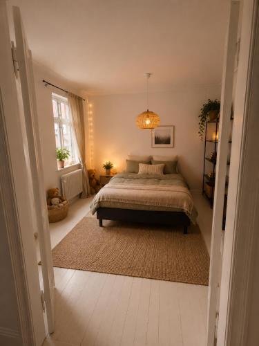 a bedroom with a bed and a chandelier at Kysthus Villa Nexø in Neksø