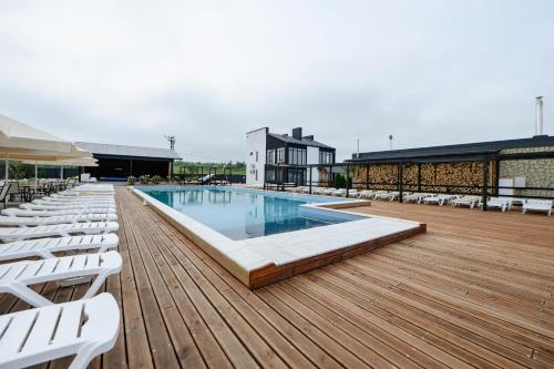 a swimming pool on a deck with white lounge chairs at California Resort and SPA in Novoyavorivsk