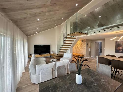 a living room with white furniture and a staircase at Villa Anita in Vela Luka