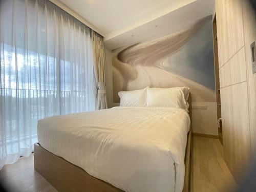a bedroom with a large bed and a large window at Sky Park Laguna Phuket in Laguna Phuket