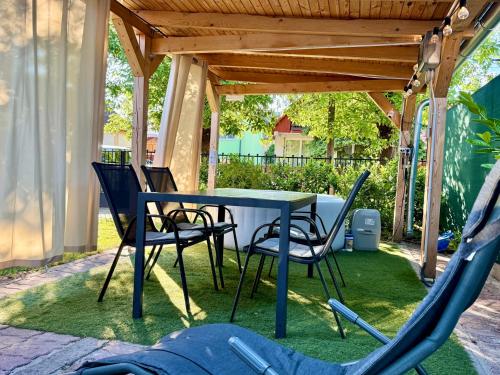 a table and chairs under a gazebo at Sparkling Time Apartman in Hajdúszoboszló