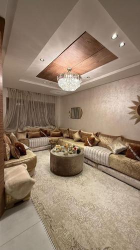 a large living room with couches and a chandelier at Appartement herrati in Kenitra