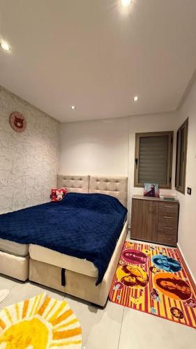 a bedroom with a large bed and a rug at Appartement herrati in Kenitra