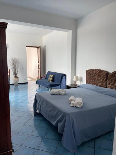 a bedroom with a blue bed with towels on it at Oltremare Residence Hotel in Lipari