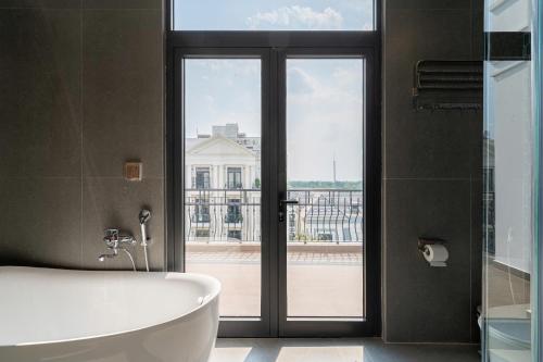 a bathroom with a tub and a large window at AviCasa - Vinhomes Grand Park in Gò Công