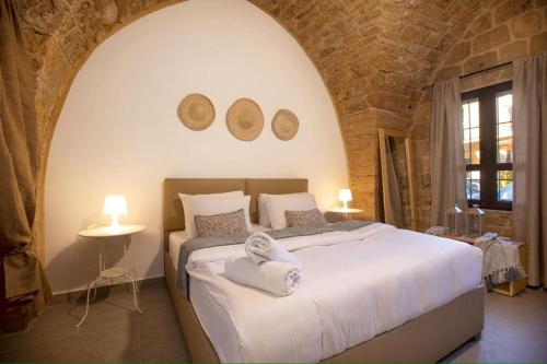 a bedroom with a large white bed with two mirrors at Casa Gia By The Sea G1 & G2 in Batroûn
