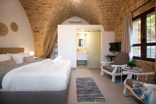 a bedroom with a large white bed and a desk at Casa Gia By The Sea G1 & G2 in Batroûn