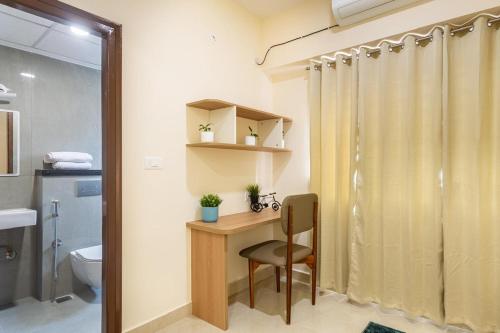 a bathroom with a desk and a toilet and a shower at Altura in Bangalore