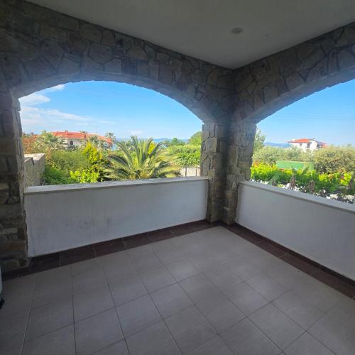 a balcony with two large windows and a view of trees at Villa Helga Exotic in Pefkochori